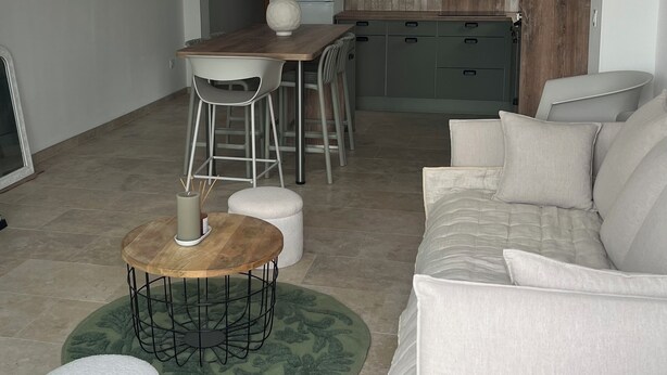 A modern living room with a sofa, a coffee table, and a dining area with a table and chairs. - Jules' keys (Gruissan)