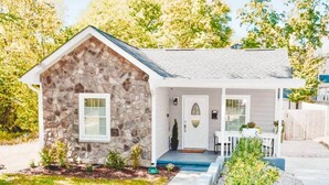 A small stone house with a front porch, a door, and a window. - Downtown - 2 bed, 2 bath (Raleigh)