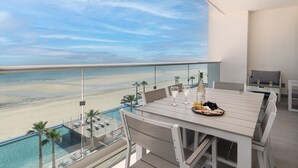 A balcony with a view of a beach and an infinity pool. - Breathtaking 2 BR 2.5 Bath Corner Beach Front Condominium Encantame 505 (Puerto Peñasco)