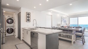 A modern kitchen with a central island, built-in appliances, and a view to the living area. - Splash in The New Lazy River and Sleep In Luxury Encantame Towers Velero 2104 (Puerto Peñasco)