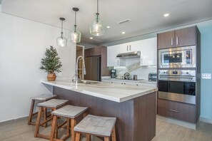 Condo, varias camas, balcón, vista al océano (Encantame Towers Verano 1002) | Cocina privada | Comedor 
