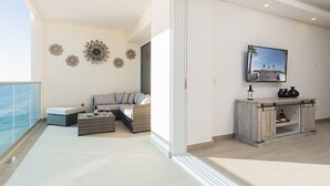 A modern living room with a sofa, coffee table, decorative wall art, and a TV mounted on the wall. - Stay in Luxury/splash in New Lazy River This Winter Encanatame Towers 902 (Puerto Peñasco)