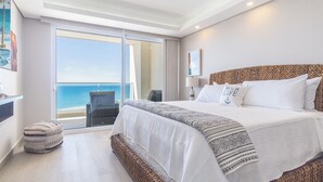 A hotel room with a large bed, a view of the sea, a balcony, and a woven headboard. - Amazing two Bedroom Beach Front Condo W405 (Puerto Peñasco)