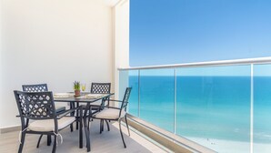 A balcony with a table set for four, chairs, a potted plant, and a glass of drink. - Encantame Towers Viento 1503 (Puerto Peñasco)