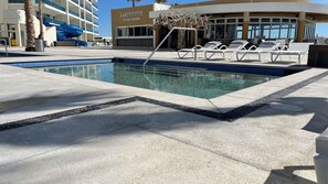 A swimming pool with lounge chairs and a water slide. - Lovely 2 Bedroom Condominium (Puerto Peñasco)