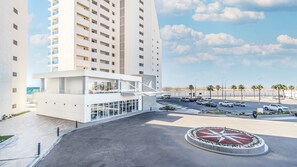 Ein modernes Hotel mit Innenhof, Parkplatz und Blick auf den Strand.