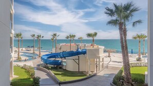 A resort with a blue water slide, palm trees, and a pool area.