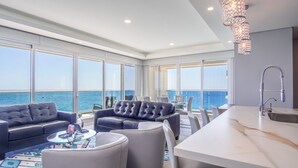 Una sala de estar moderna con vista al océano, una zona de bar y un comedor.