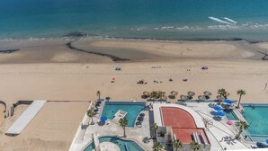 Un resort con piscina, playa y vista al océano.