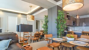 Un espace repas moderne avec une table en verre, des chaises en bois et un canapé en cuir.