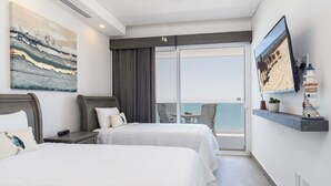 A hotel room with two beds, a large window with a view of the beach, a mounted TV, and a small table with a plant. - Splash in The New Lazy River and Sleep In Luxury Encantame Towers C 1202 (Puerto Peñasco)