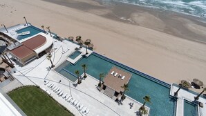 An aerial view of a resort with a swimming pool, beach, and lounge area. - Splash in The New Lazy River and Sleep In Luxury Encantame Towers C 1202 (Puerto Peñasco)