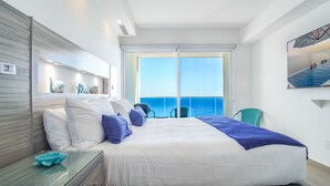 A modern hotel room with a large bed, a view of the sea, and a balcony. - Perfect Family 2 Bedroom Condo E1804 Encantame (Puerto Peñasco)
