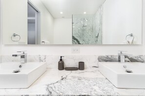 A modern bathroom with two sinks, a large mirror, and marble countertops. - Spectacular 2 Bedroom 2bathroom Beach Front Condominium at Encantame C1002 (Puerto Peñasco)