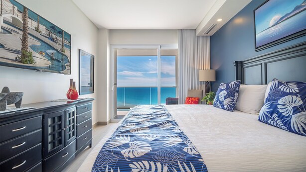 Ein Hotelzimmer mit einem großen Bett, Meerblick, einem Balkon und modernem Design.