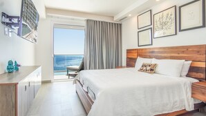 Een hotelkamer met een bed, een bureau, een stoel, een raam met gordijnen en lijstwerken aan de muur.