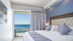 A hotel room with a large bed, a nightstand, a lamp, and a view of the ocean through a sliding door. - Looking for the Perfect Scape From the City? Peaceful 2 Bedroom Condo Verano 804 (Puerto Peñasco)
