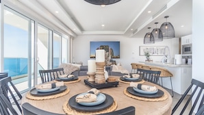 A modern dining area with a round table set for six, surrounded by black chairs. - Wonderful 1 Bedroom Condominium Encantame Verano 2103 (Puerto Peñasco)