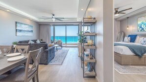 A modern hotel room with a balcony, a dining area, and a bedroom. - Waterfront Getaway 2 Bedroom Condo W1102 (Puerto Peñasco)