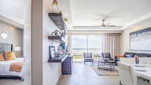 A modern hotel room with a bed, seating area, and a balcony with a view. - Spectacular 2 Bedroom Condominium Encantame E102 (Puerto Peñasco)