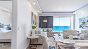A modern hotel room with a balcony, a sofa set, a dining table, and artwork on the walls. - A Style Of Its Own 2 Bedroom Unit Encantame Viento 1202 (Puerto Peñasco)