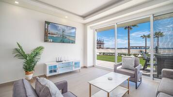 Condo, varias camas, balcón, vista al océano (Encantame Towers Verano 104) | Área de sala de estar | Televisión de pantalla plana de 42 pulgadas con canales digitales