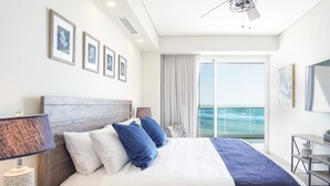 A hotel room with a bed, a desk, a TV, and a view of the ocean. - Sublime 1 Bedroom Condo Encantame Towers Verano 503 (Puerto Peñasco)
