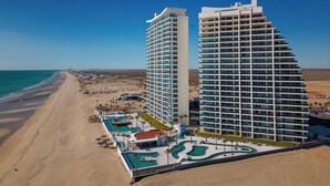 A modern hotel with a pool area and beach access. - Sublime 1 Bedroom Condo Encantame Towers Verano 503 (Puerto Peñasco)