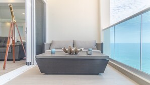 A modern living area with a sofa and a coffee table, a telescope, and a view of the sea. - Amazing Condo by the Beach Encantame W1203 (Puerto Peñasco)