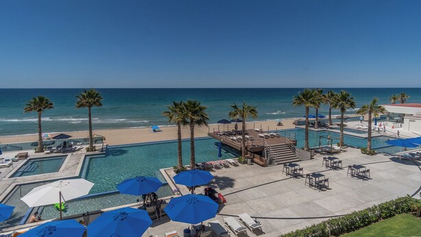 A resort with a pool area, beach access, and palm trees. - Amazing Condo by the Beach Encantame W1203 (Puerto Peñasco)