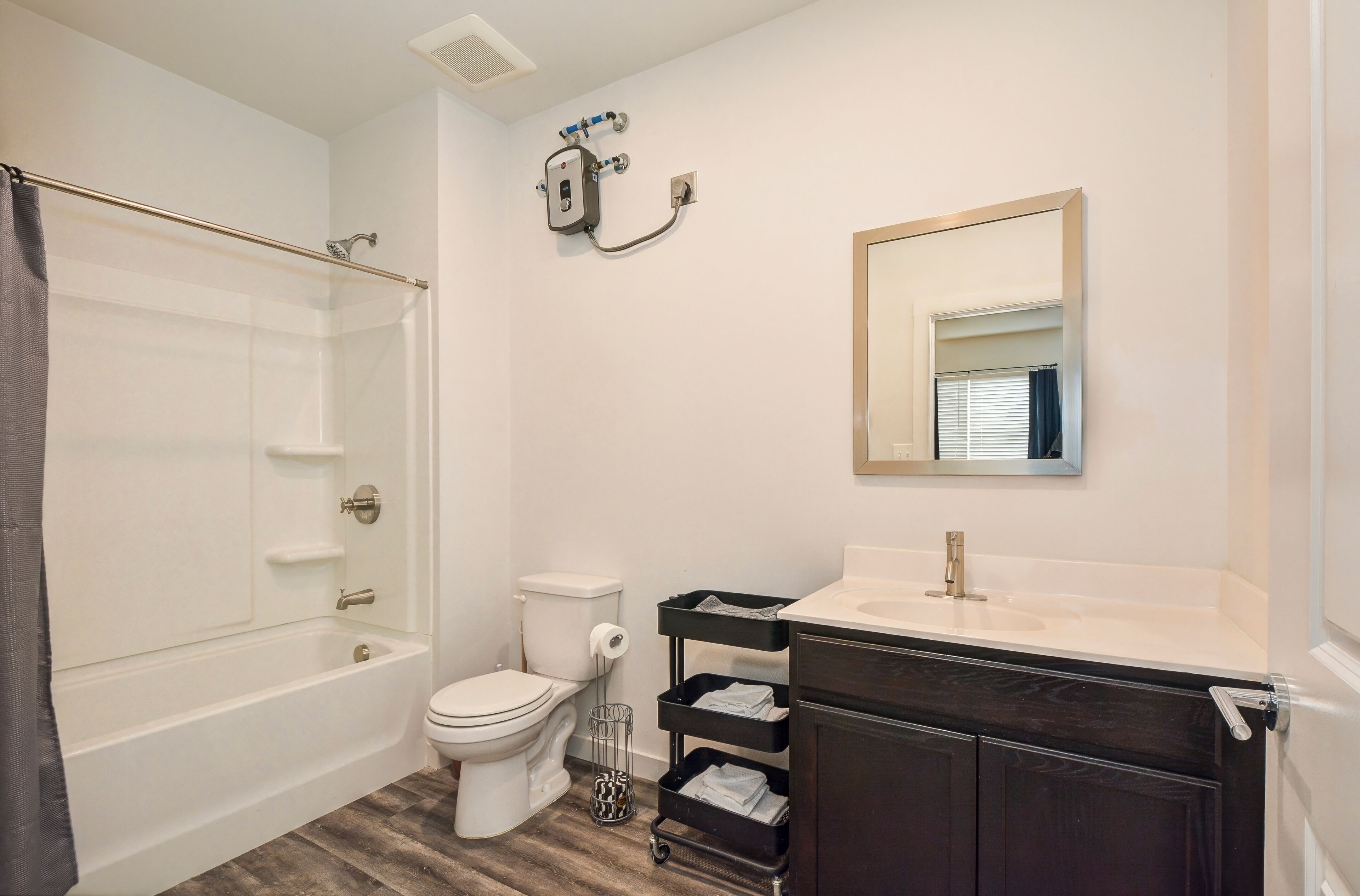 Une salle de bain avec une baignoire, des toilettes, un lavabo et un miroir.