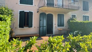 A two-story house with a balcony, a small patio, and a large potted plant. - Marciaga, rustic in ancient hamlet (Veneto)