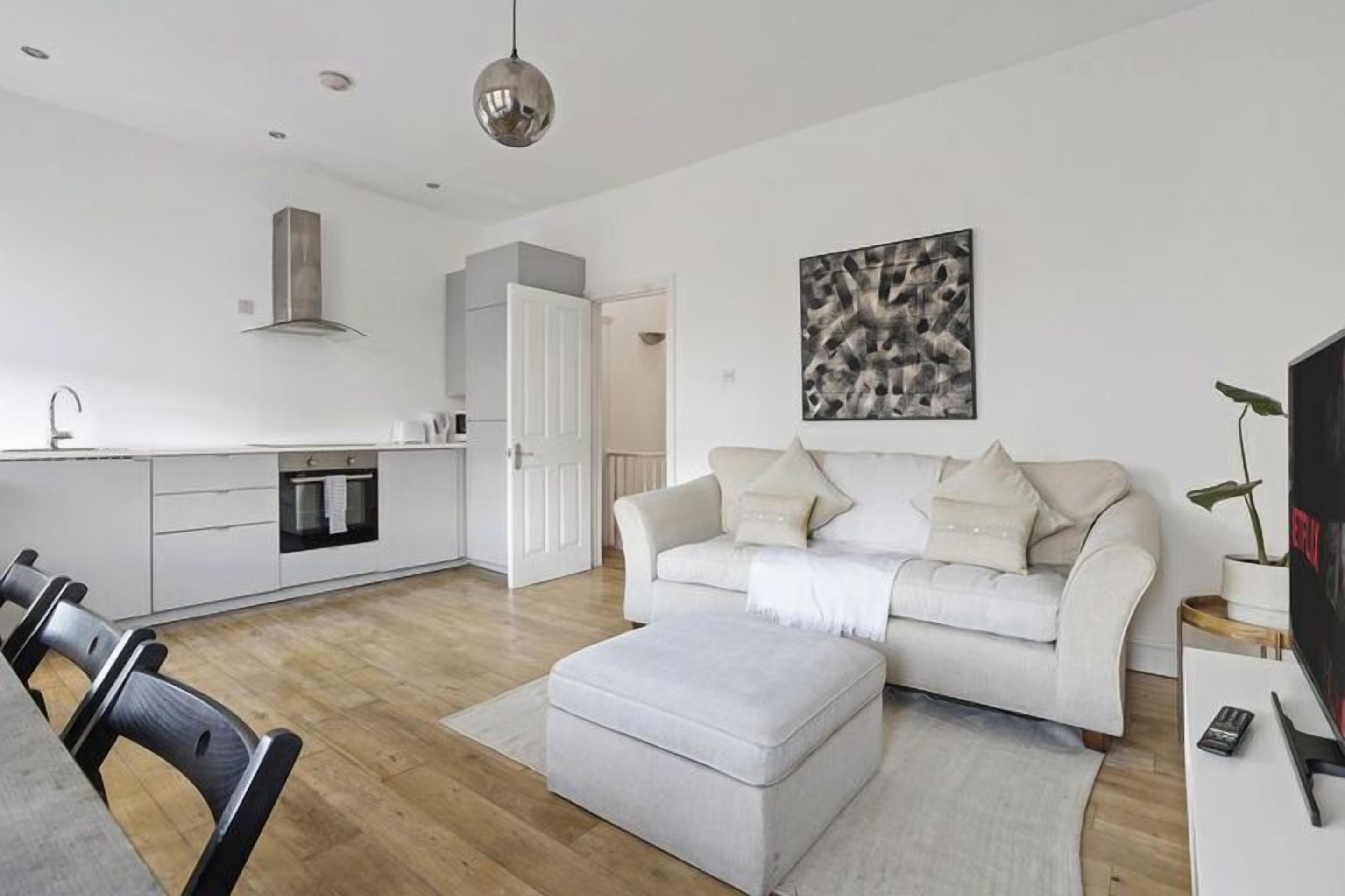 A modern living space with a kitchen, dining area, and seating area.
