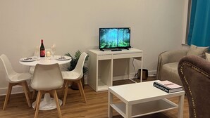 A modern living room with a dining area, a flat-screen TV, a Louis Vuitton book, and a brown armchair. - Nice 1-bedroom apartment in Namur (Namur)