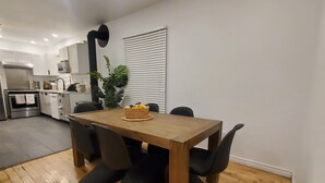 A modern kitchen with white cabinets, a wooden dining table, and black chairs. - Superb apartment near Longueuil metro station (Longueuil)