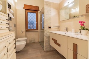 Een douche, een haardroger, een bidet, handdoeken