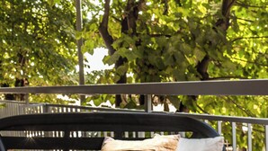 A black bench with two pillows, one beige and one white, in a park with green trees and a metal railing in the background. - Caffarella Vacanze, comfort and relaxation a few minutes from the heart of Rome (Roma)