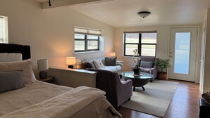 Ein geräumiges Schlafzimmer mit einem großen Bett, einer Sitzecke mit Sofa und Sesseln sowie einem Esstisch.