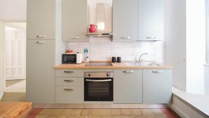 A modern kitchen with grey cabinets, a microwave, a toaster, and a sink. - BuddyRent - Vatican Domus - 4 ospiti (Rome)