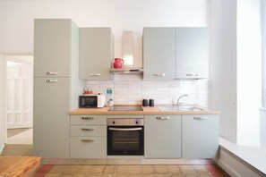 A modern kitchen with grey cabinets, a microwave, a toaster, and a sink.