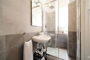 Chuveiro, secador de cabelo, toalhas de banho, shampoo