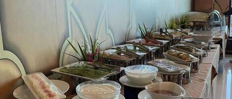 A buffet setup with various food items and dishes.