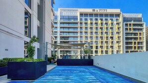 Un edificio moderno con area piscina in piastrelle blu e zona relax coperta.