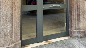 Entrada de un edificio con puerta de vidrio y manija de metal.