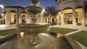 A fountain in a courtyard with a building in the background.