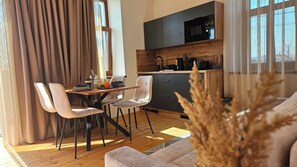 Una cocina moderna con microondas, armarios de madera y una zona de comedor con mesa y sillas.