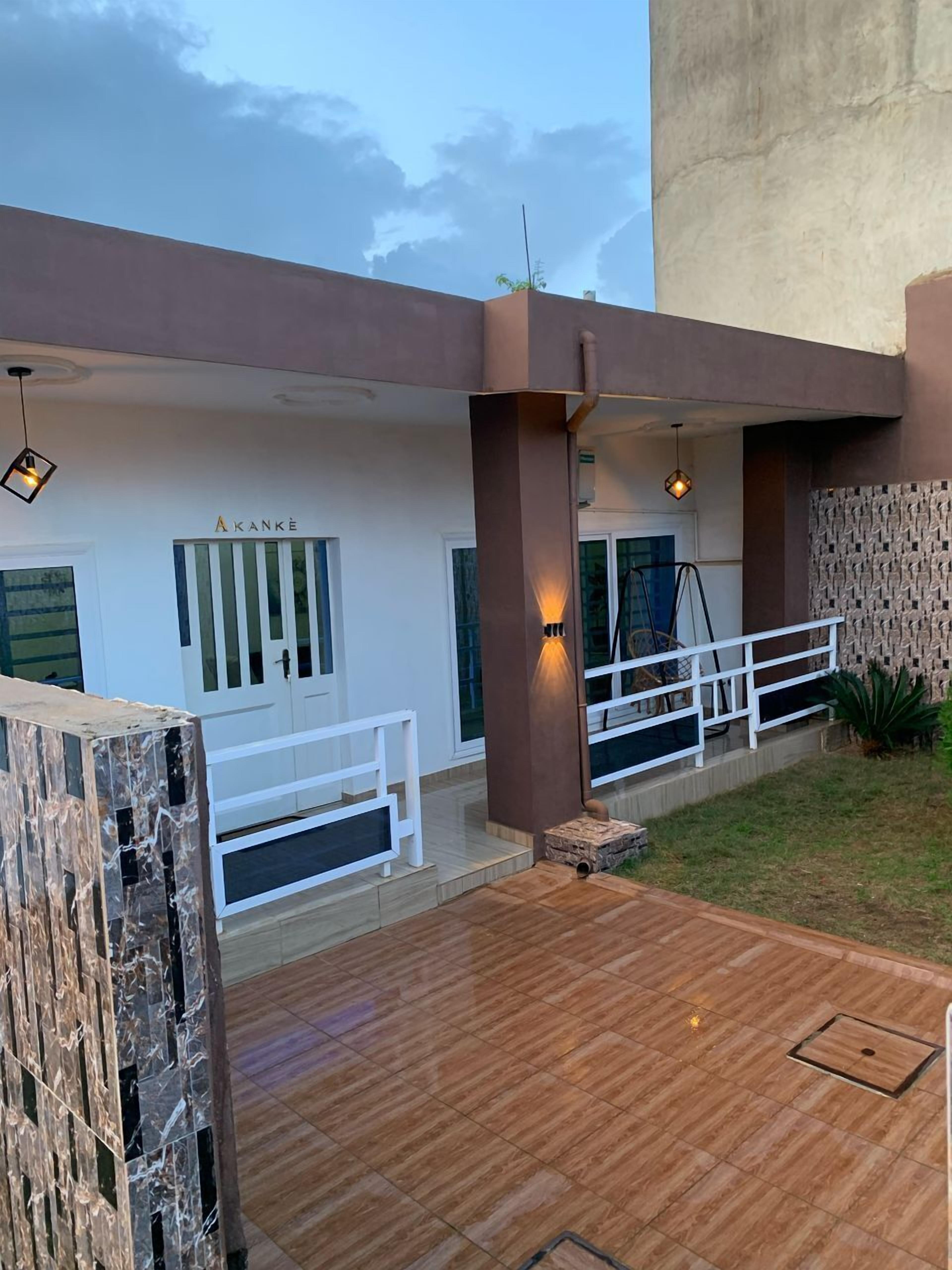 A modern building with a white facade, a wooden deck, and a white railing.