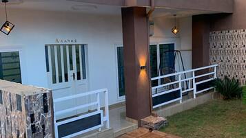 A modern building with a white facade, a wooden deck, and a white railing.