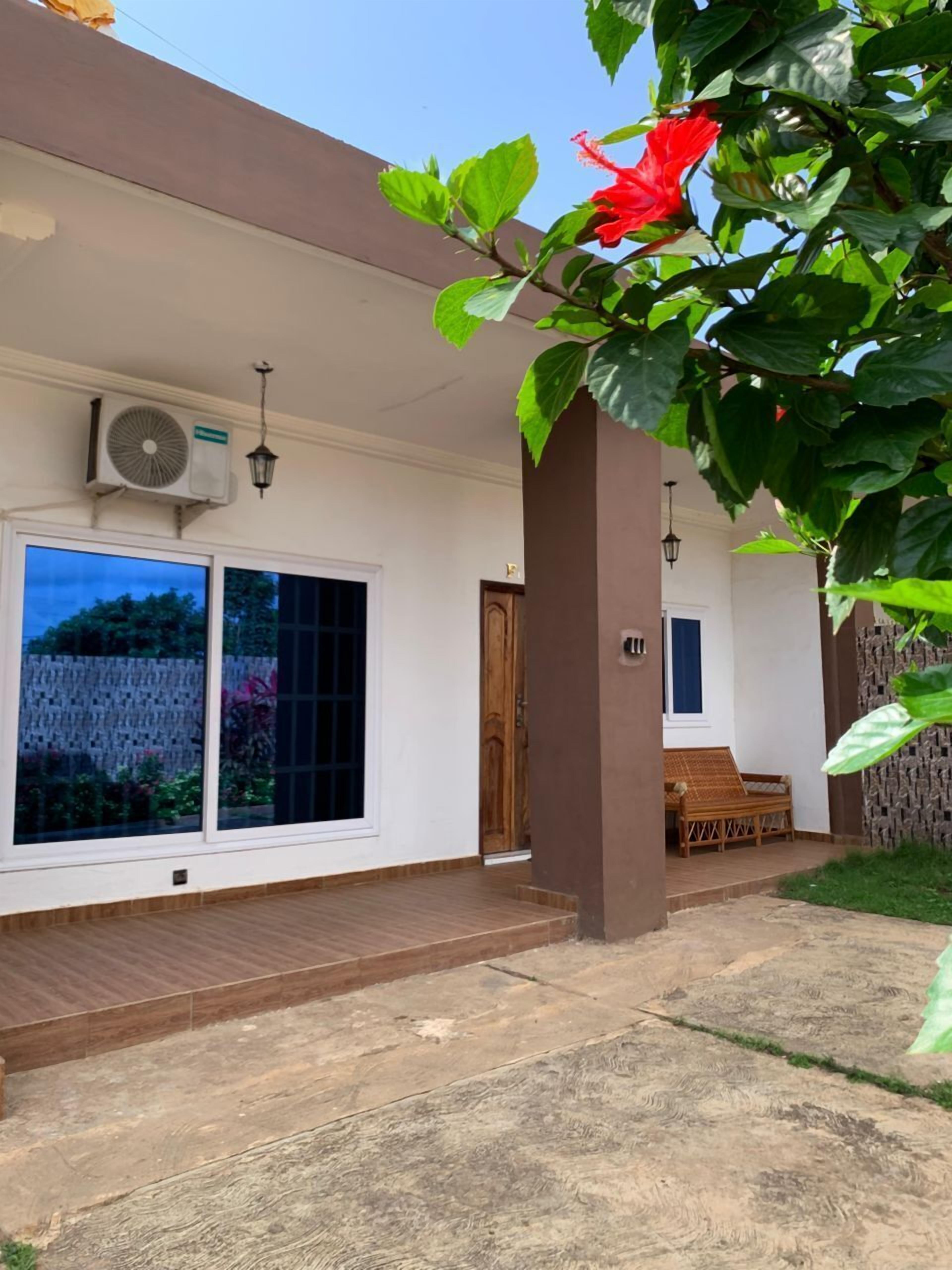 Uma casa moderna com uma janela grande, uma porta e um pequeno alpendre.