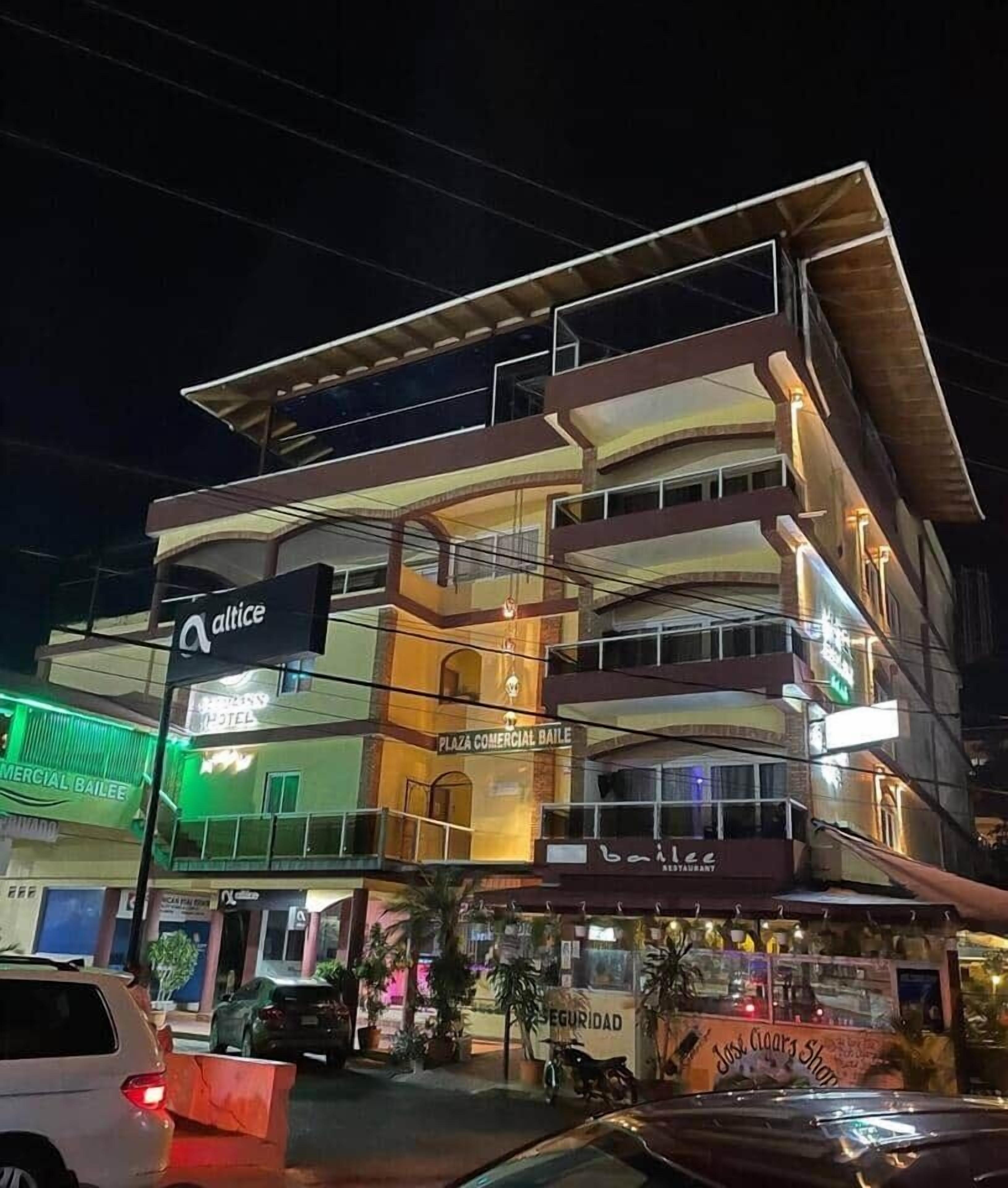 A multi-story building with commercial spaces on the ground floor, including a restaurant and a security service.